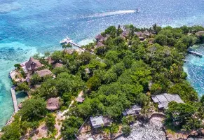 a) A una isla con arrecifes